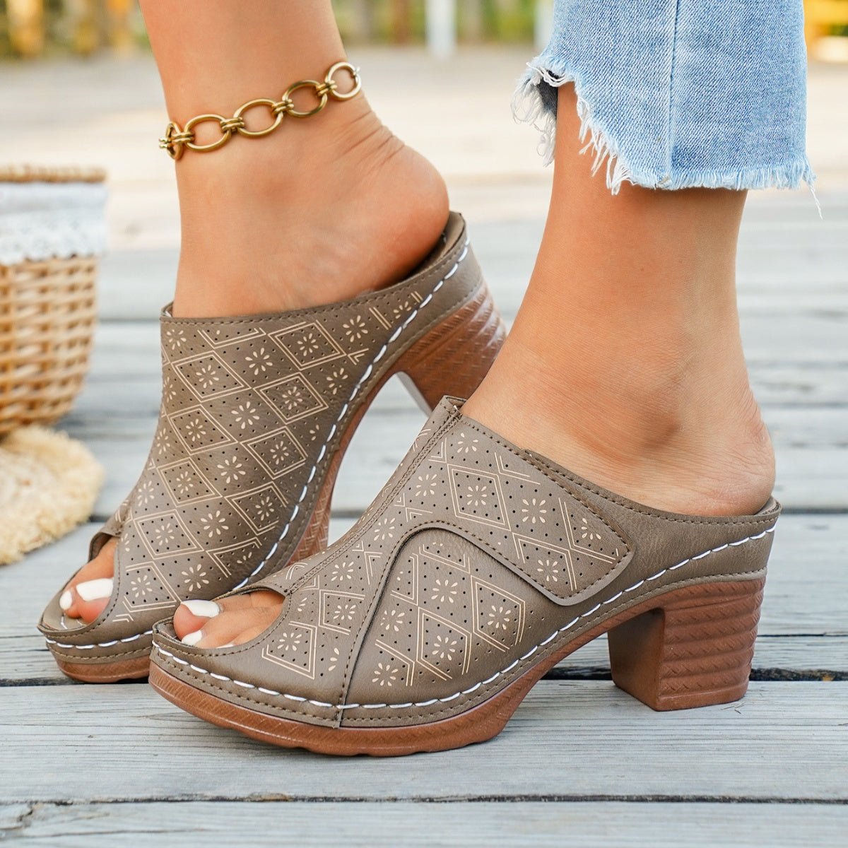 Tan peep-toe mules with perforated diamond pattern and block heel.