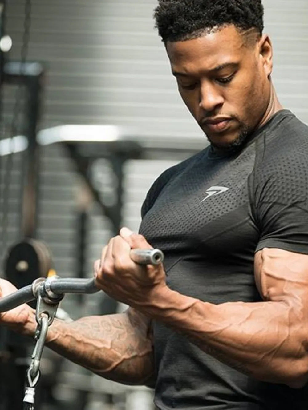 Black performance fit raglan sleeve tee with textured pattern and short sleeves.