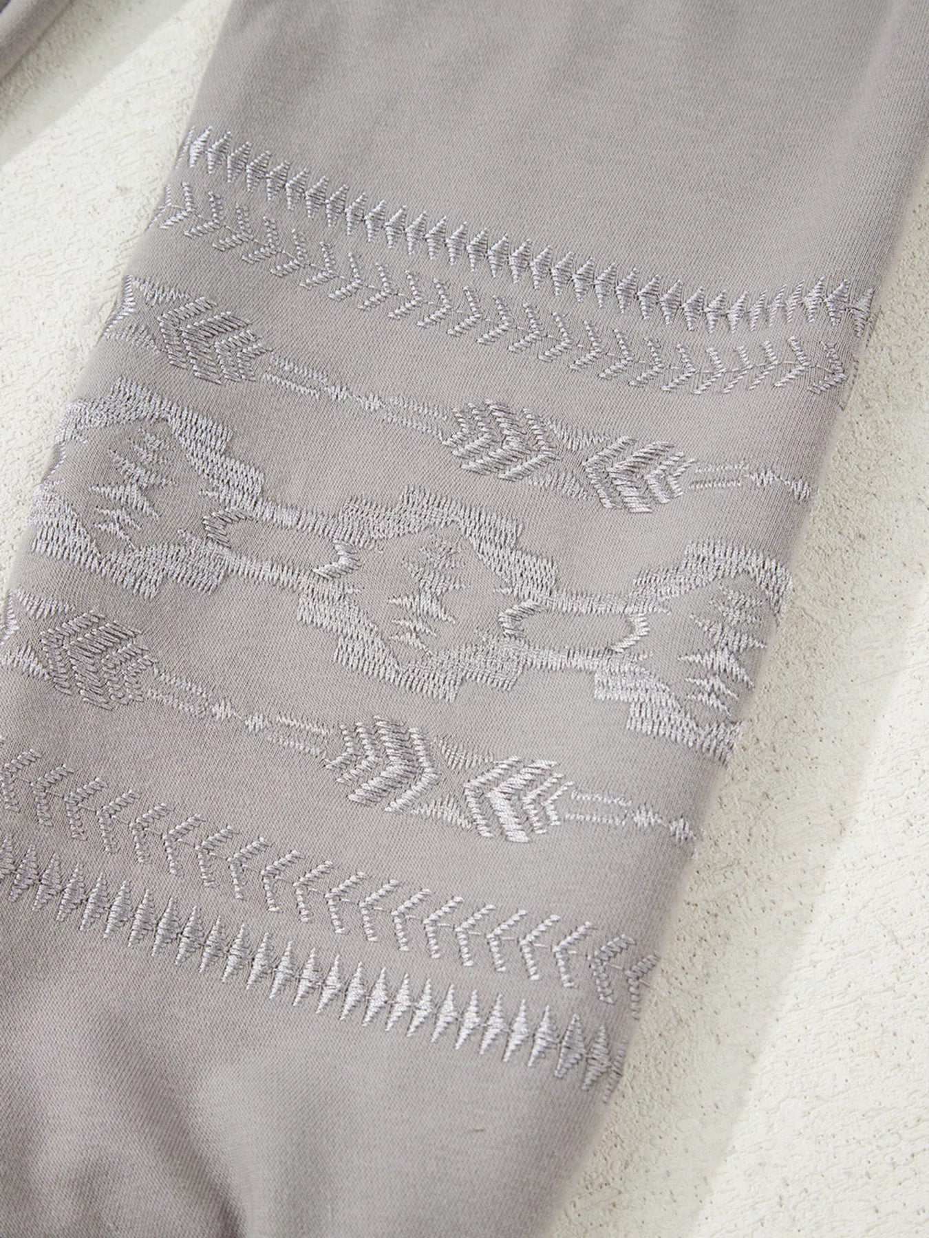 Gray sweatshirt with Aztec embroidery detail on sleeve