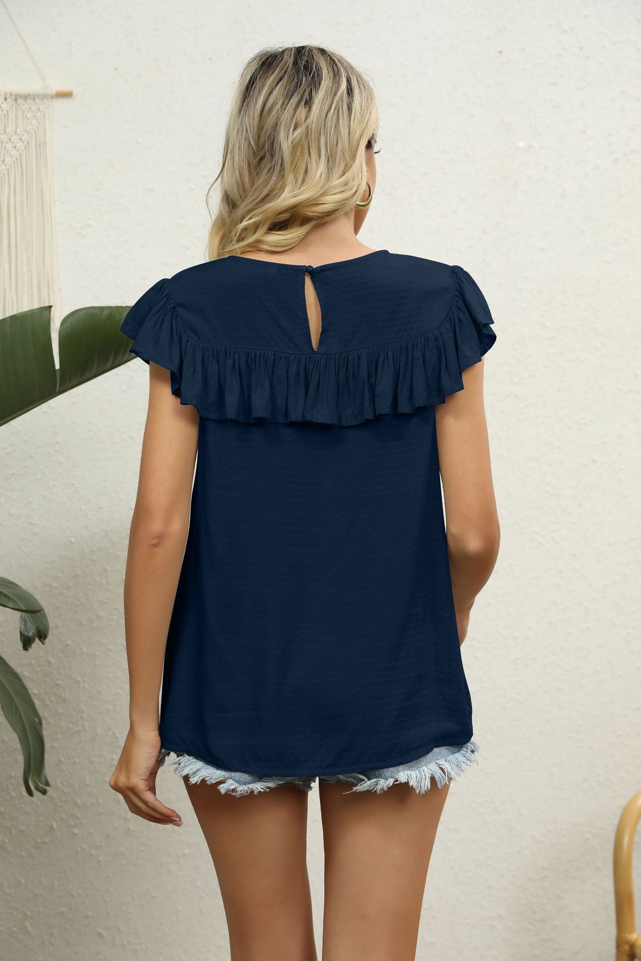 Dark blue blouse with ruffle yoke and short ruffle sleeves, keyhole back detail.