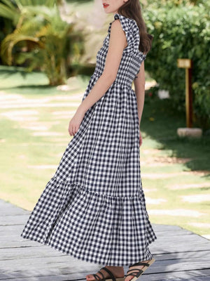 Black gingham midi dress with smocked bodice and ruffled sleeves.