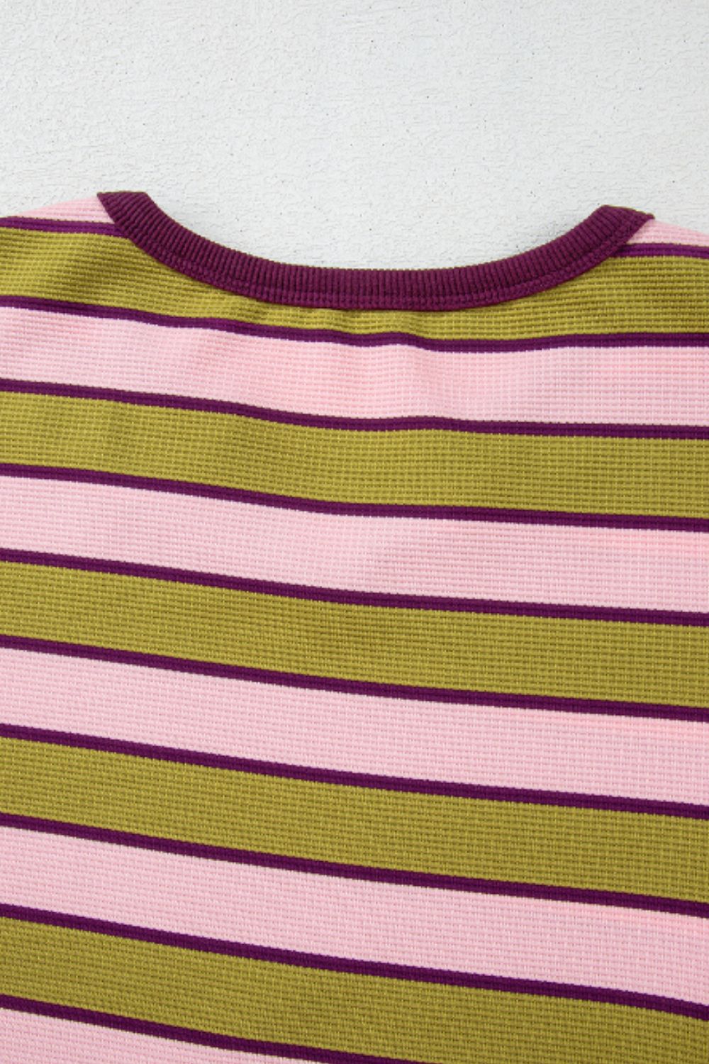 Waffle knit cropped top with pink, olive green, and purple stripes and a ribbed neckline.