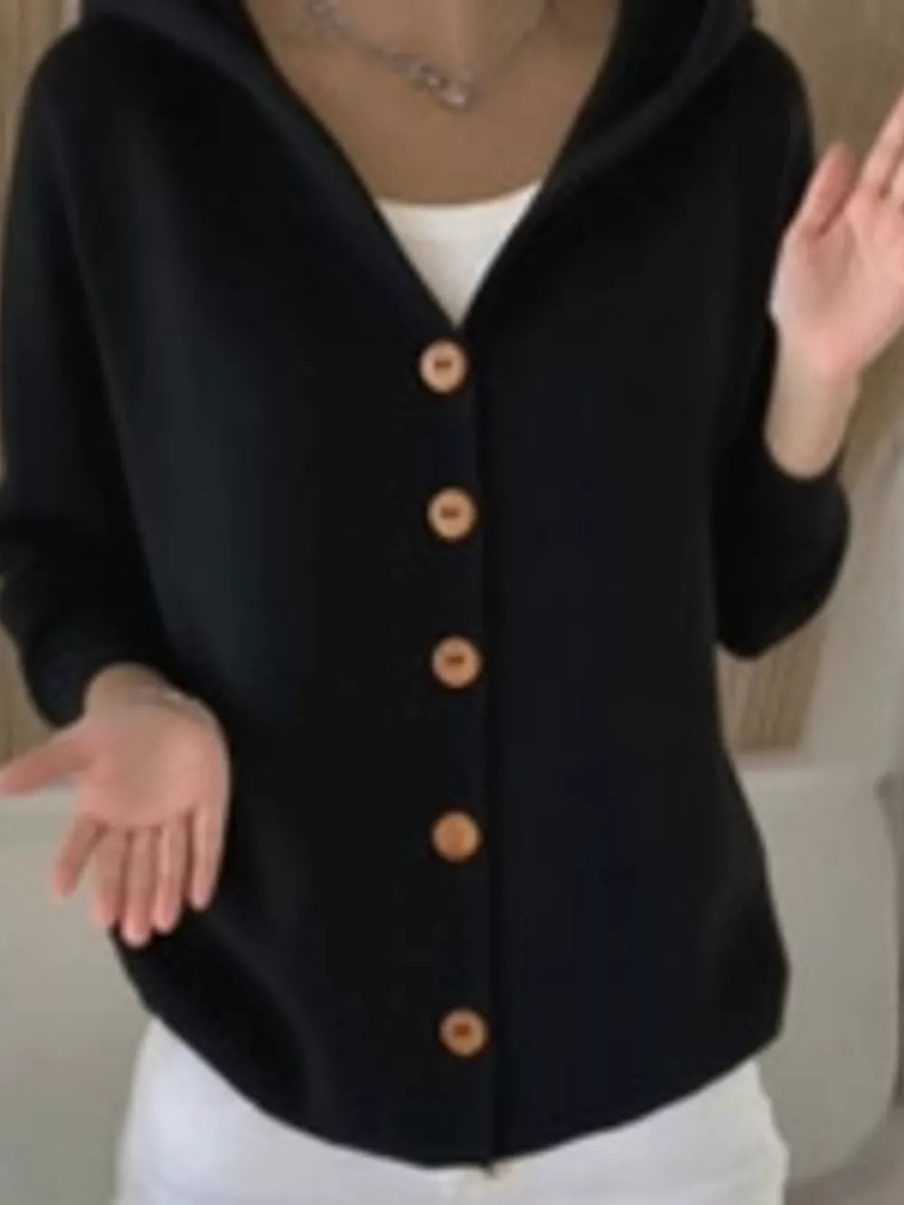 Black hooded knit cardigan with button-front detail and wooden buttons.