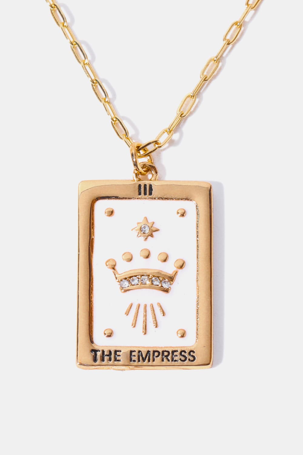 Gold tarot card pendant necklace with white enamel, crown, and crystals.