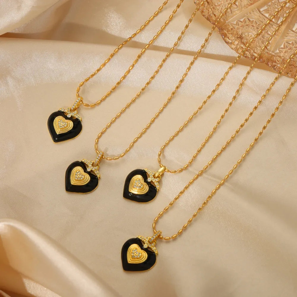 Gold necklace with black enamel heart pendant and diamond accents