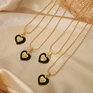 Gold necklace with black enamel heart pendant and diamond accents