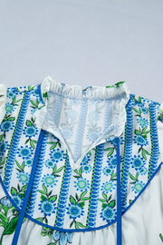 White polyester shirt with blue floral print, tie-neck, and ruffled collar.