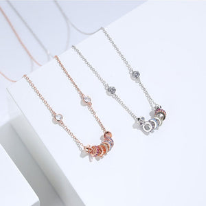 Sterling circle pendant necklace in rose gold and silver with colorful gemstone accents.