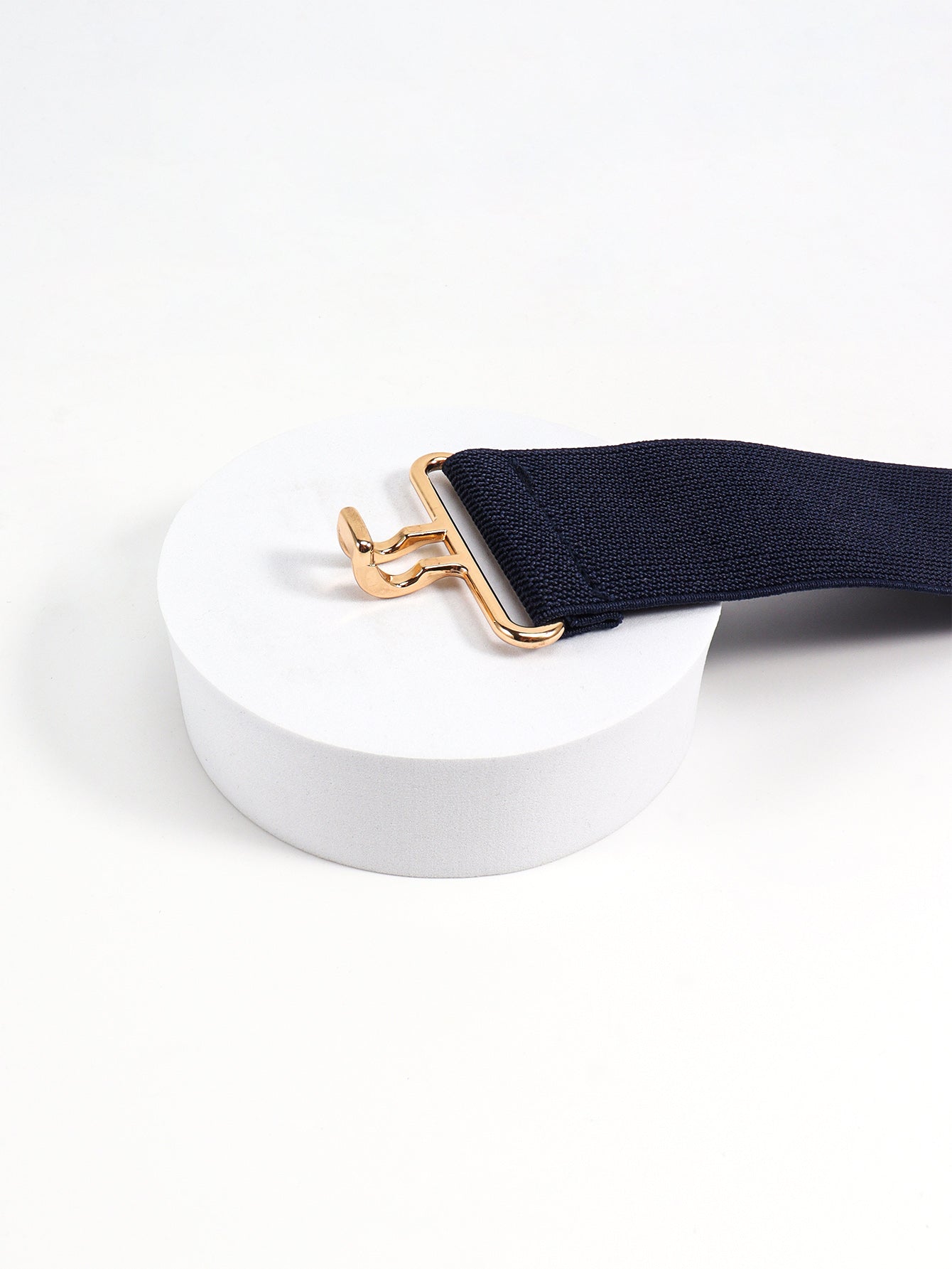 Dark blue elastic belt with a sculpted gold buckle detail