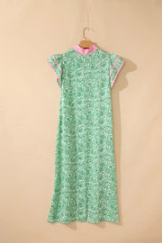 Green botanical print midi dress with flutter sleeves and pink trim.
