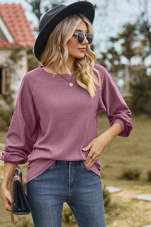Lilac waffle knit eyelet raglan sleeve top with crew neck and cuffed sleeves.