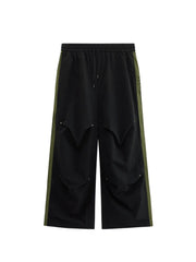 Black relaxed fit sweatpants with drawstring and olive green side stripe detail.
