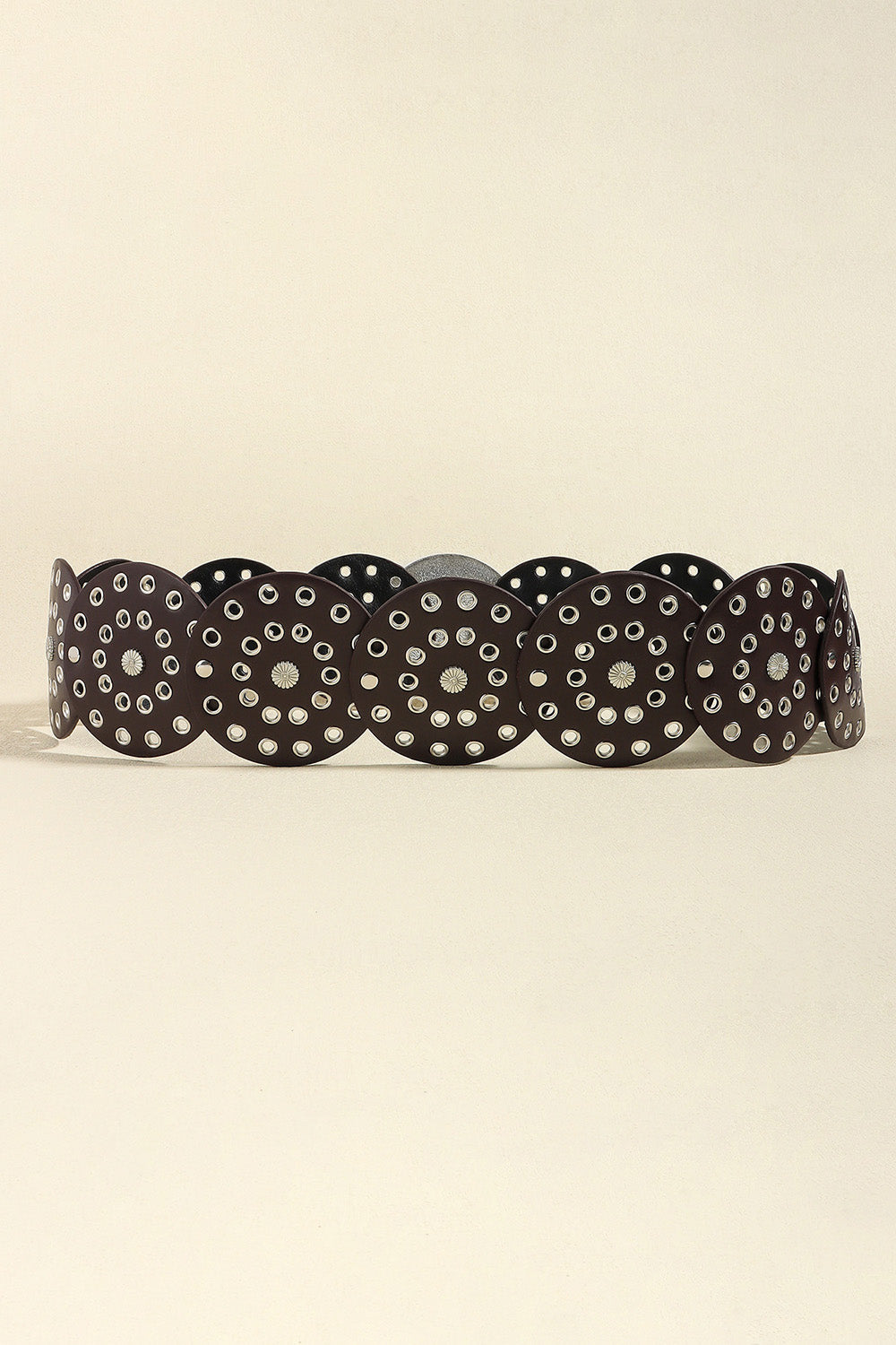 Disc-embellished belt in brown with silver eyelets and floral details.