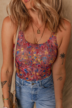 Floral mesh bodysuit with scoop neck and ruched detail, styled with denim.