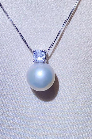 Solitaire pearl pendant necklace in silver with a cubic zirconia accent on a sterling silver chain.