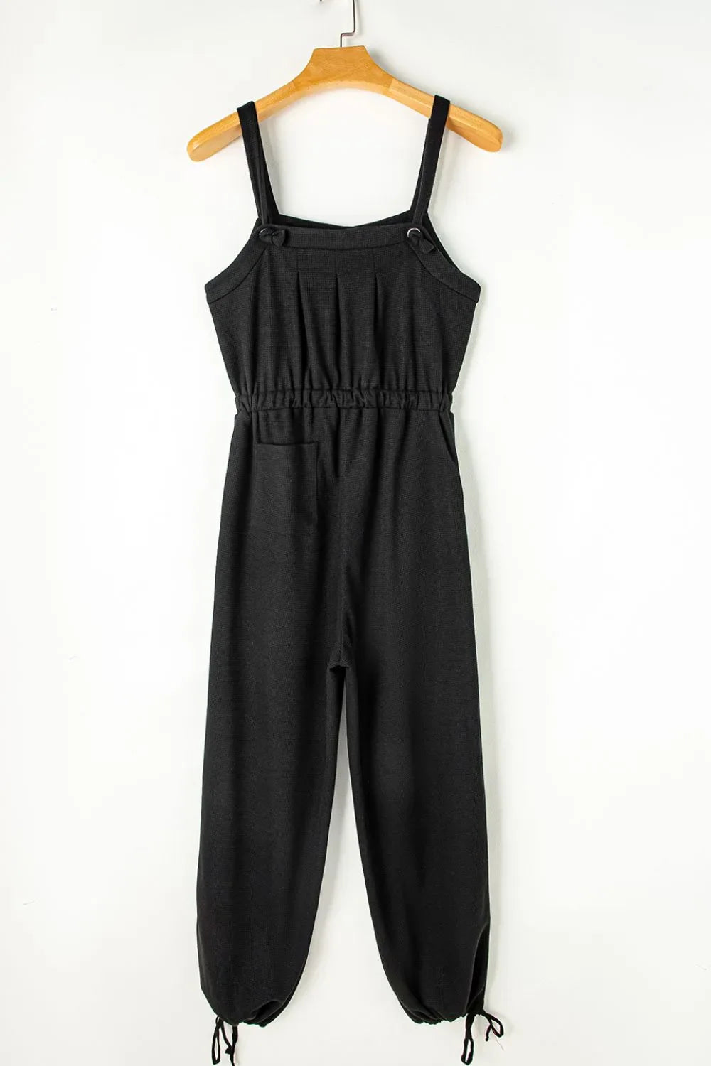 Black waffle knit wide leg jumpsuit with adjustable straps and drawstring waist