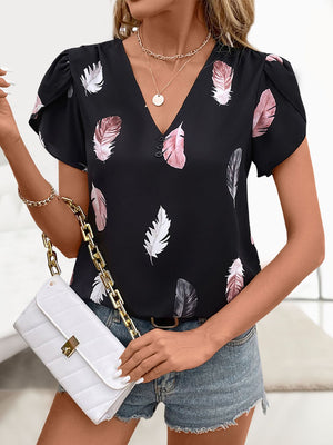 Black feather print blouse with V-neck, puff sleeves, and button detail.