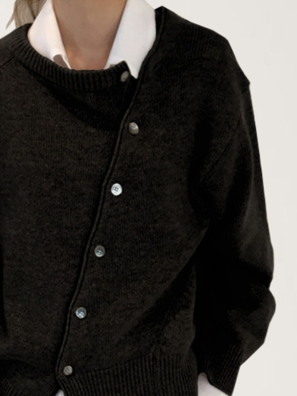 Dark gray asymmetric button-up knit cardigan with a white collared shirt layered underneath.