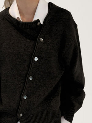 Dark gray asymmetric button-up knit cardigan with a white collared shirt layered underneath.