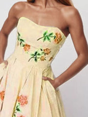 Floral print strapless maxi dress in blush pink with pockets and a full skirt.