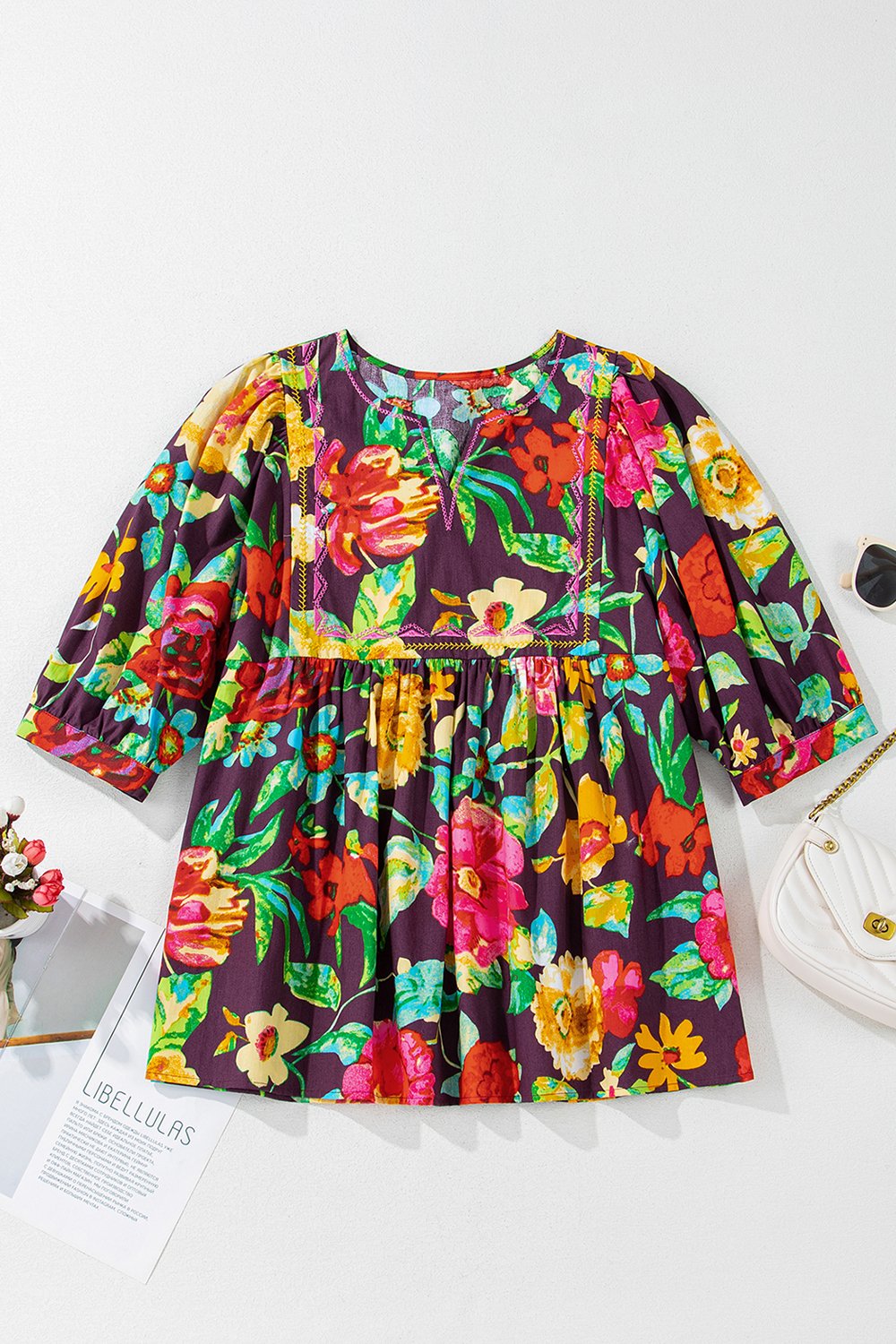 Embroidered floral babydoll blouse with V-neck and puff sleeves in a vibrant floral print.