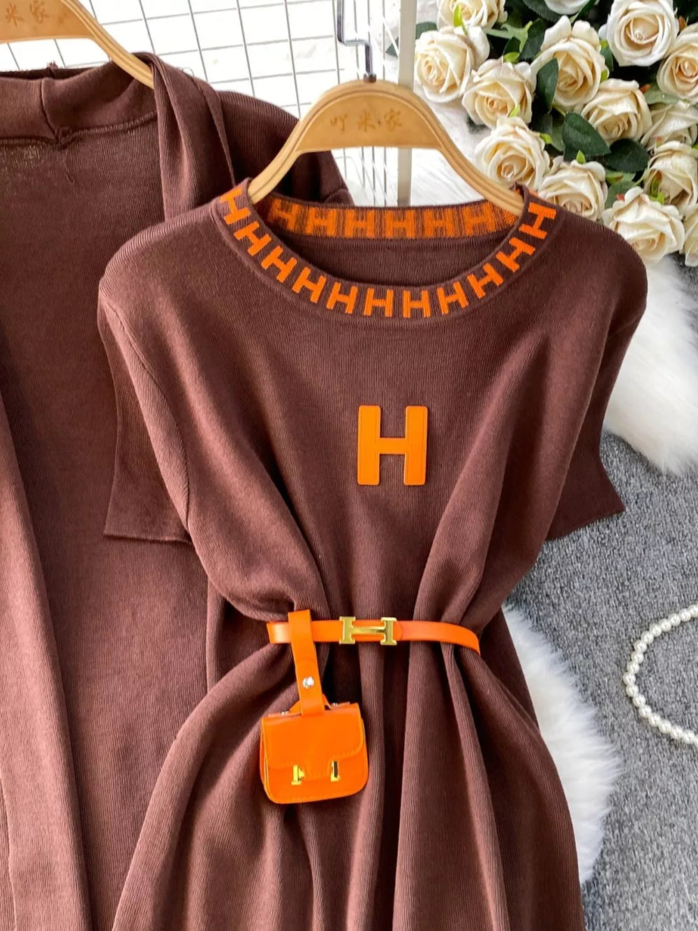 Brown knitted maxi dress ensemble with orange trim and belt detail.