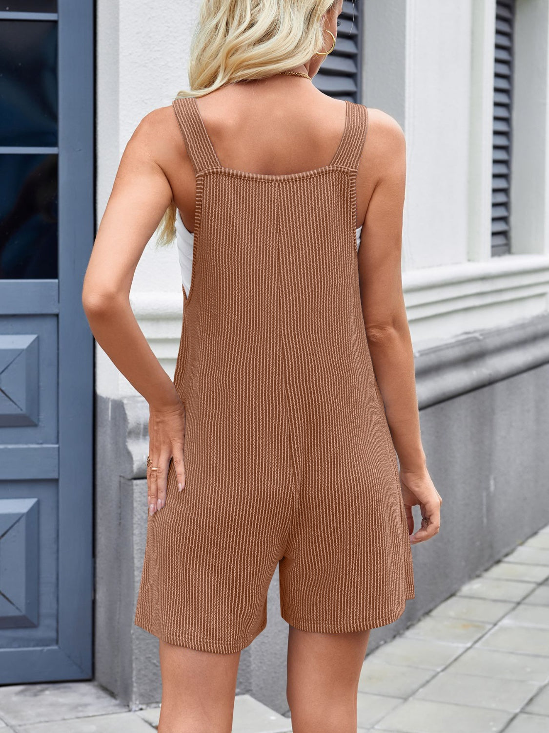 Caramel ribbed romper overalls with adjustable straps and short legs.