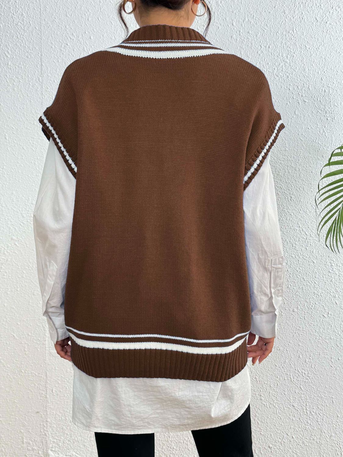 Chocolate acrylic knit vest with contrast trim and ribbed hem, styled over a white shirt.
