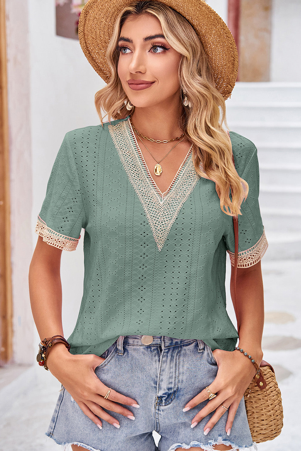 Sage eyelet v-neck blouse with lace trim and short sleeves.