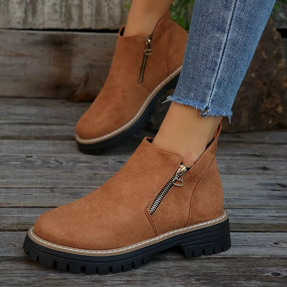 Brown suede ankle boots with side zipper and rugged sole.