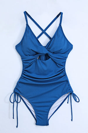 Ribbed one-piece swimsuit in Peacock Blue with a cutout, tie detail, and adjustable side ties.