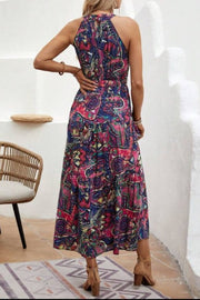 Halter neckline maxi dress with a vibrant paisley print and a cinched waist.