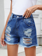 Distressed denim cutoff shorts with raw hem in medium wash, featuring ripped details.