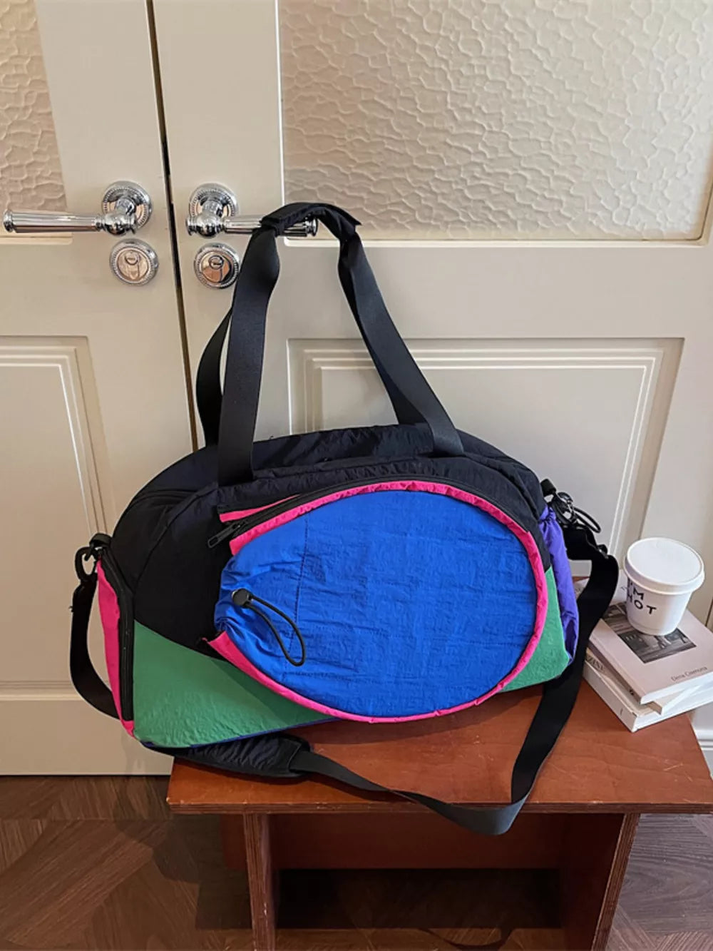 Vibrant nylon sport duffle bag with adjustable strap and bold color block design.