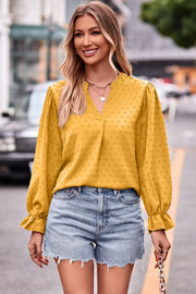 Gold textured dot v-neck blouse with ruffle cuffs and long sleeves