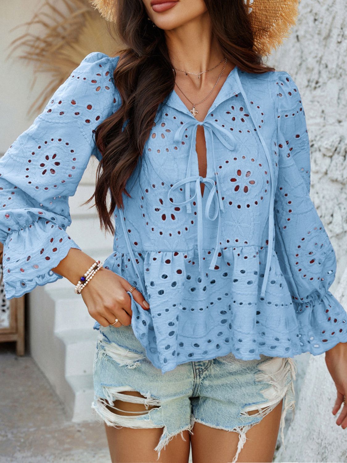 Light blue eyelet embroidered peplum blouse with tie neck and ruffled sleeves