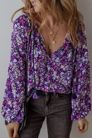 Floral print blouse in electric purple with blouson sleeves and tassel details.