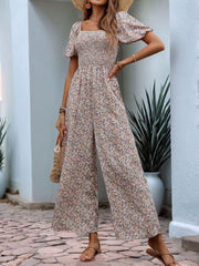 Floral smocked bodice jumpsuit with wide legs and puff sleeves, in a dusty pink floral print.