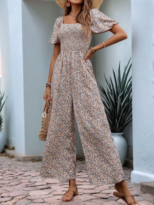 Floral smocked bodice jumpsuit with wide legs and puff sleeves, in a dusty pink floral print.