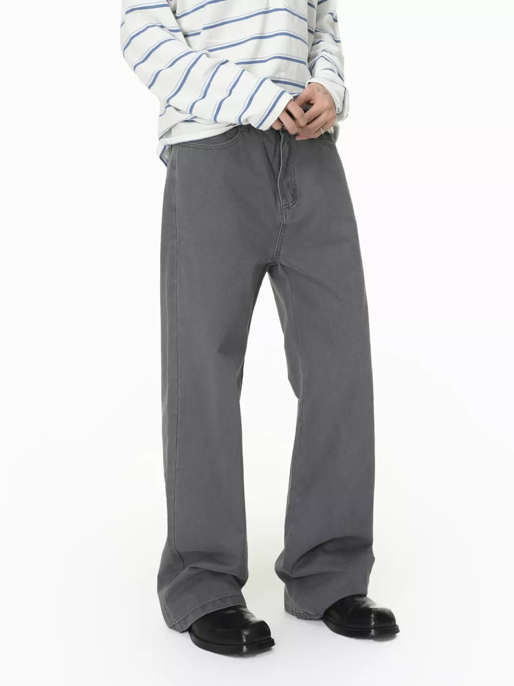 Men's relaxed fit grey cotton jeans with a buttoned closure, styled casually.