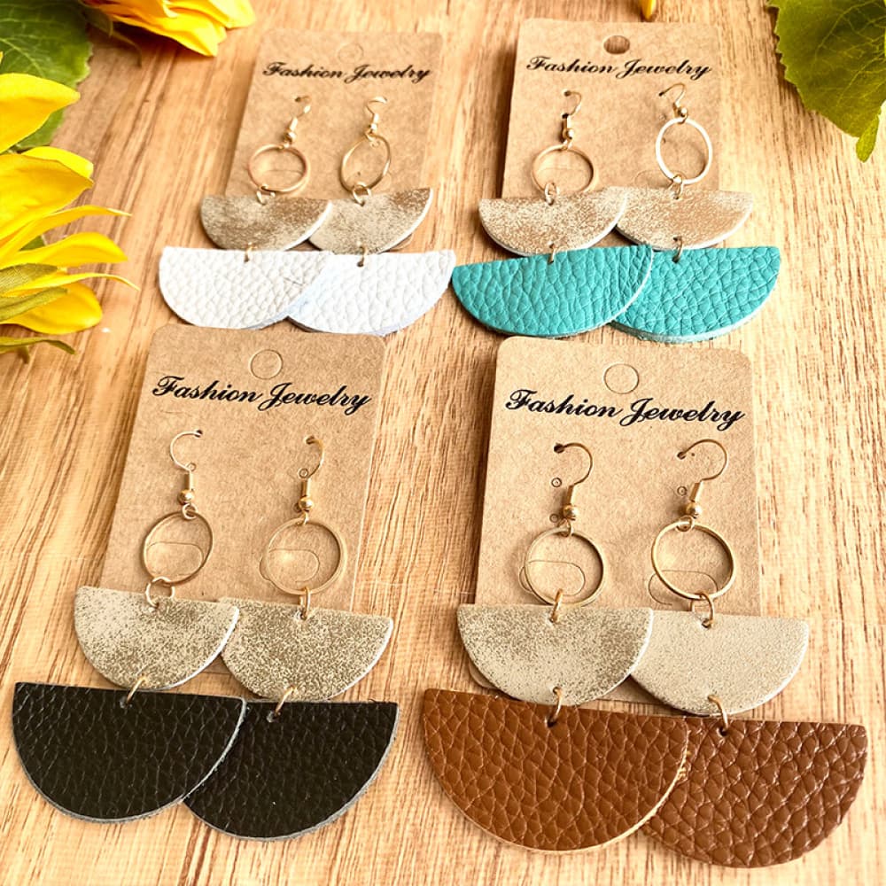 Textured leather half-moon earrings in white, aqua, black, and caramel with metallic tops.