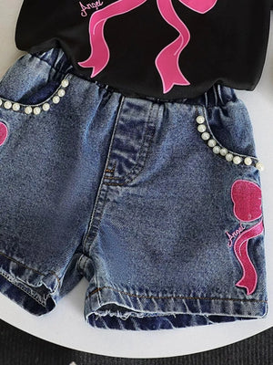 Baby denim shorts with pearl trim and pink bowknot embroidery, paired with a black tee.
