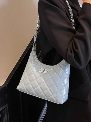 Light blue quilted pu leather shoulder bag with silver chain strap and turn-lock closure.