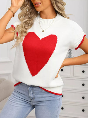 White acrylic knit top with red heart graphic, crew neck, ribbed accents, and short sleeves.