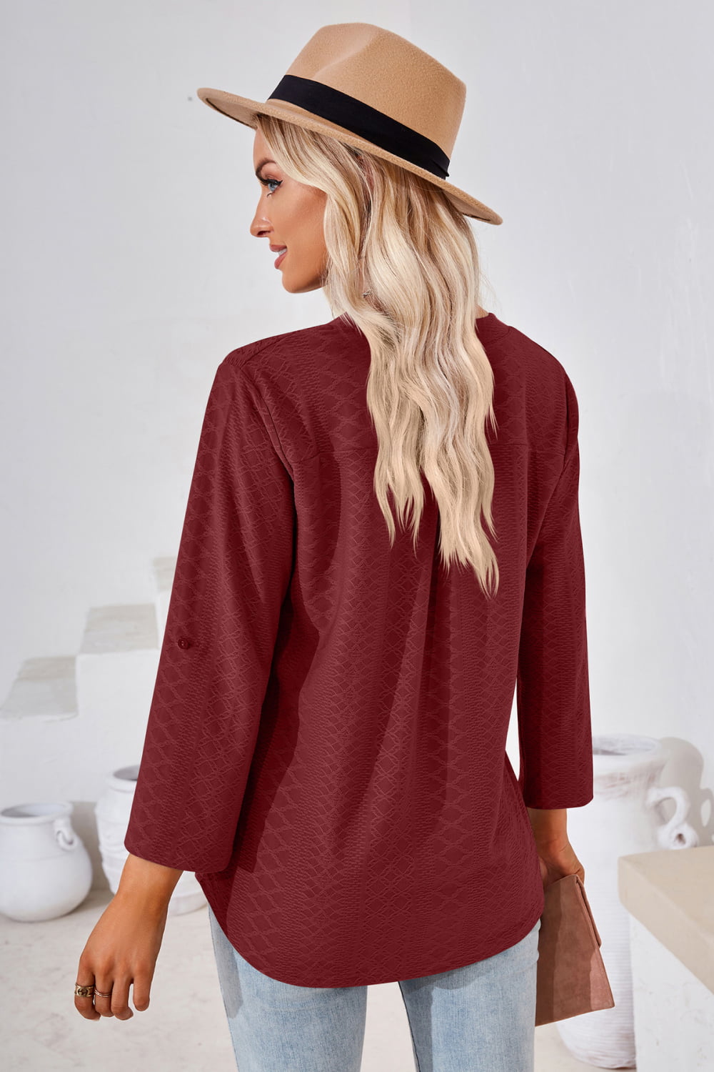 Burgundy textured blouse with rolled sleeves and button detail.