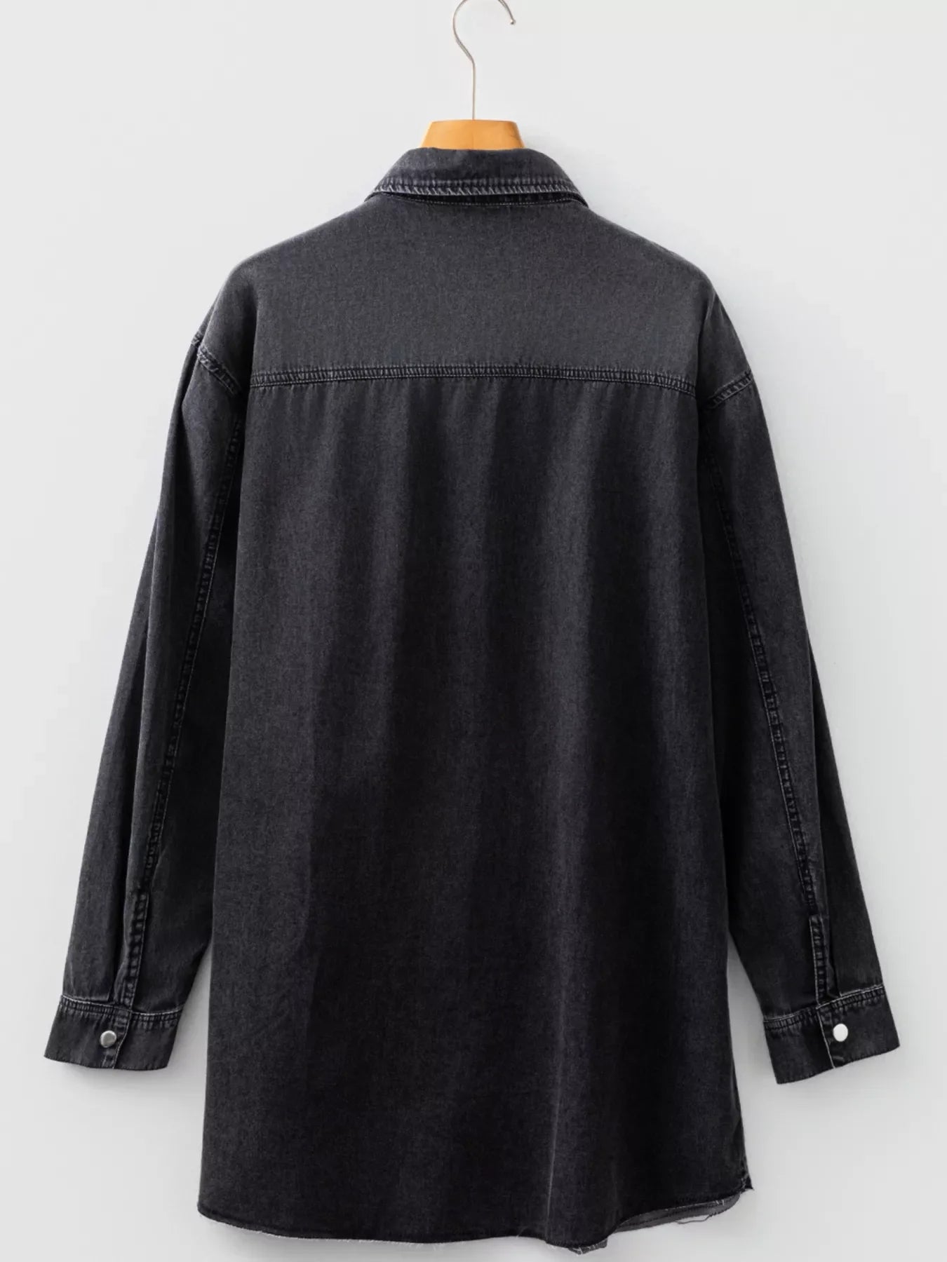 Black denim button-up dress with raw hem and long sleeves.