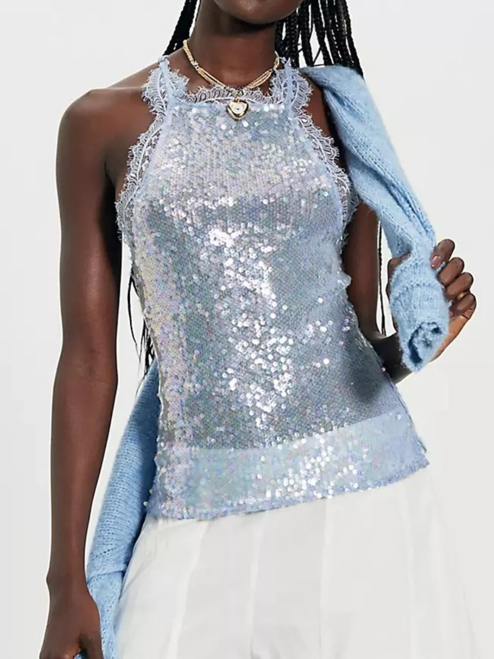 Blue sequin halter cami with lace trim and a subtle sheen, styled with a blue knit sweater draped over the shoulder.