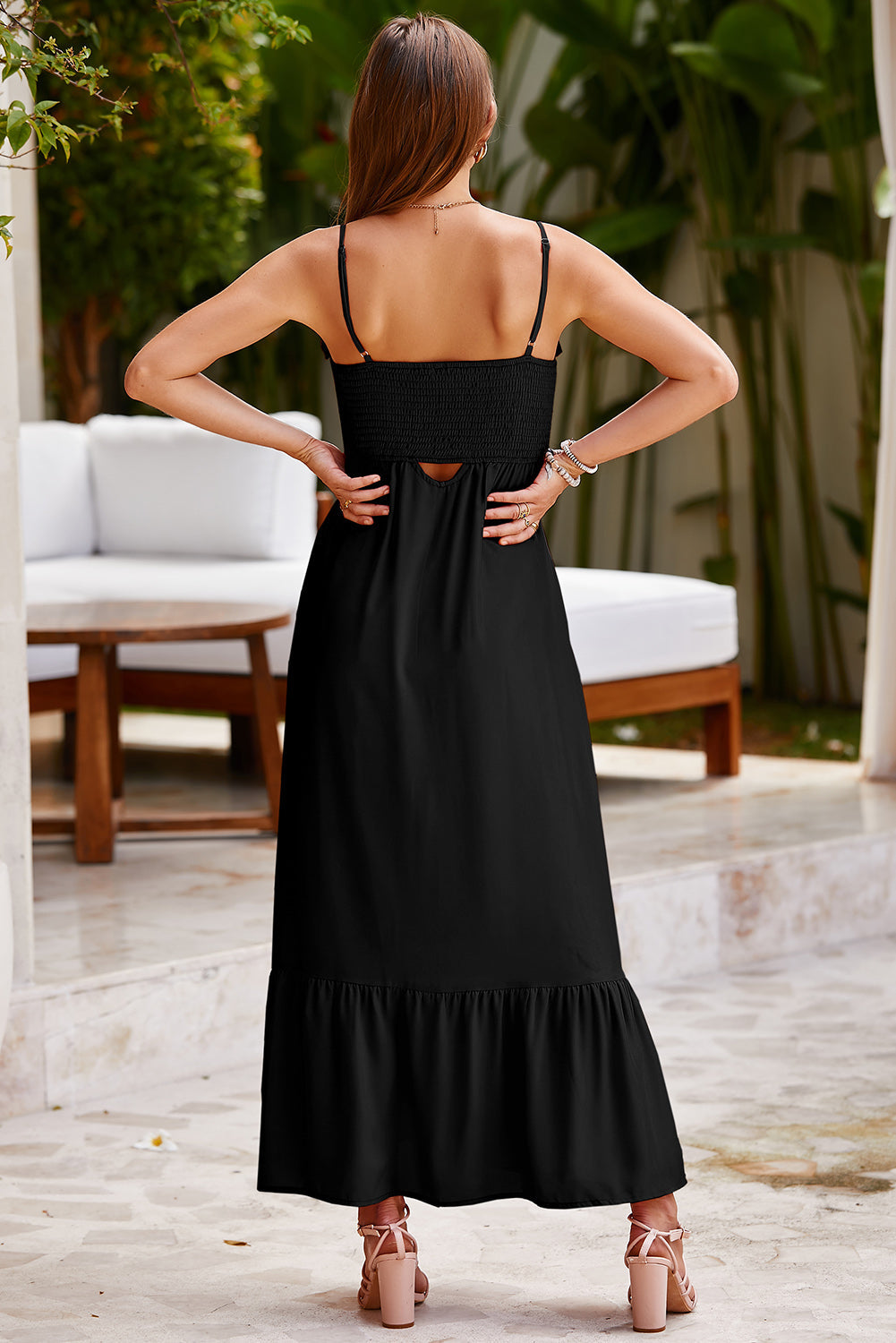 Black smocked bodice maxi dress with spaghetti straps and a cutout detail.