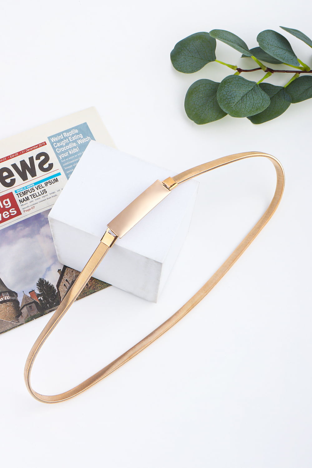Slimline gold-tone metal waist belt with a rectangular buckle.
