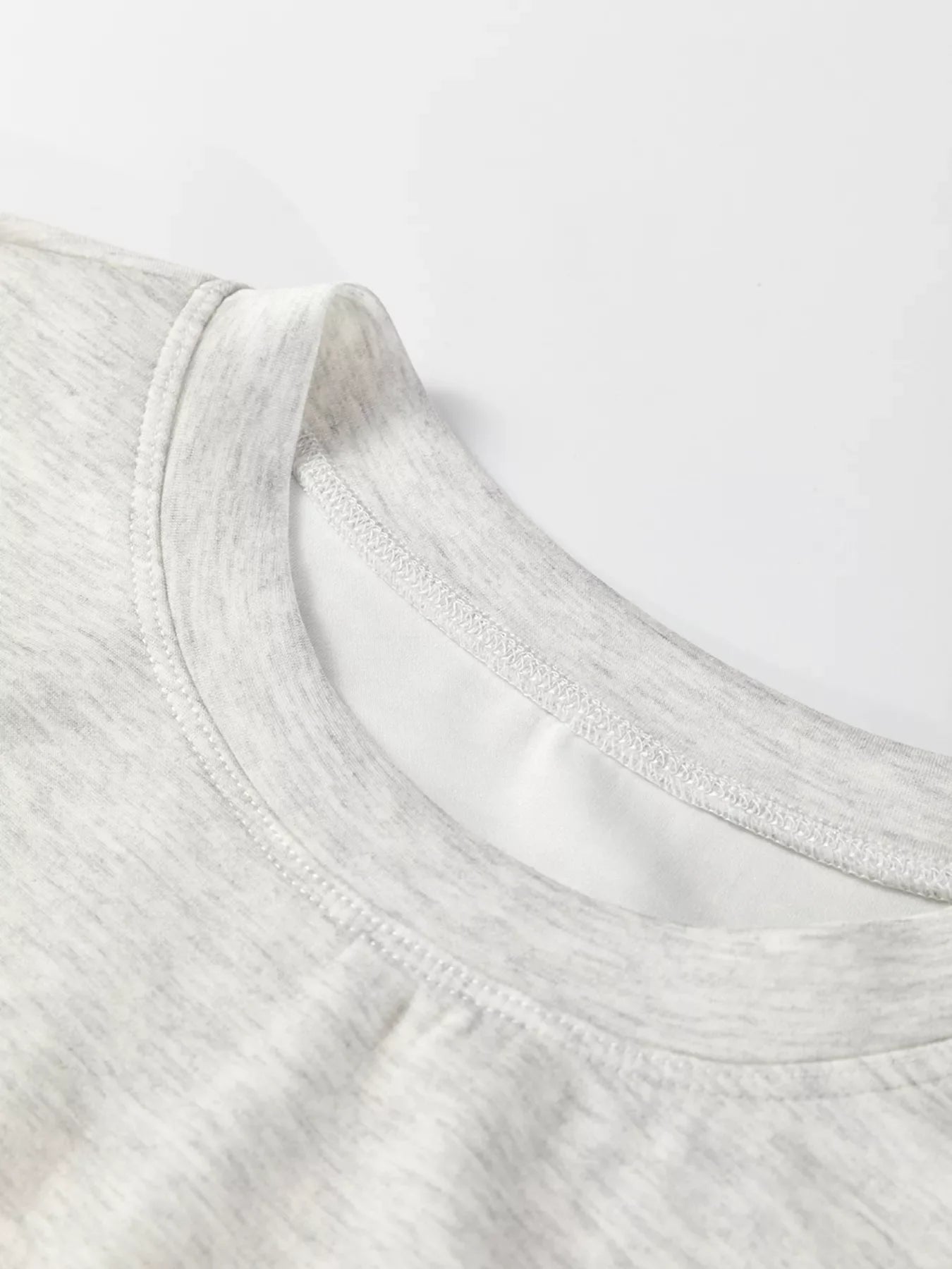 Light gray marled tunic sweatshirt with crew neck and visible stitching detail.
